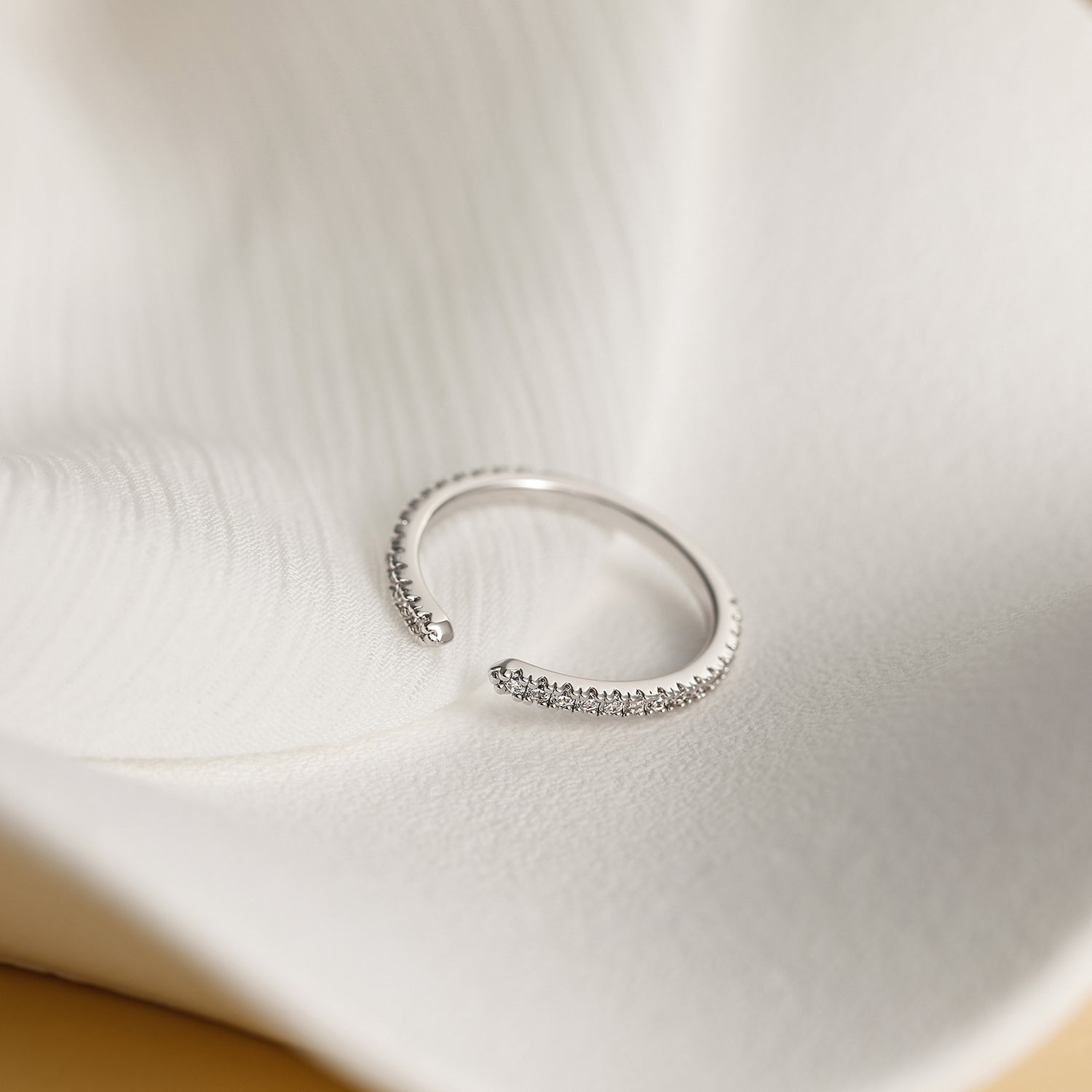 unusual womens wedding bands​, 5A CZ band ring, modern promise ring, cubic zirconia Rings, cz ring, wedding rings cz, eamti rings, cheap wedding rings under $50, copper ring, open band rings, open wedding band​. Silver ring with small stones on a textured beige surface