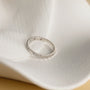 minimalist wedding band ring, 5A CZ band ring, modern promise ring, cubic zirconia Rings, cz ring, wedding rings cz, eamti rings, cheap wedding rings under $50, copper ring,stackable ring. Silver ring with small diamonds on a white ceramic dish