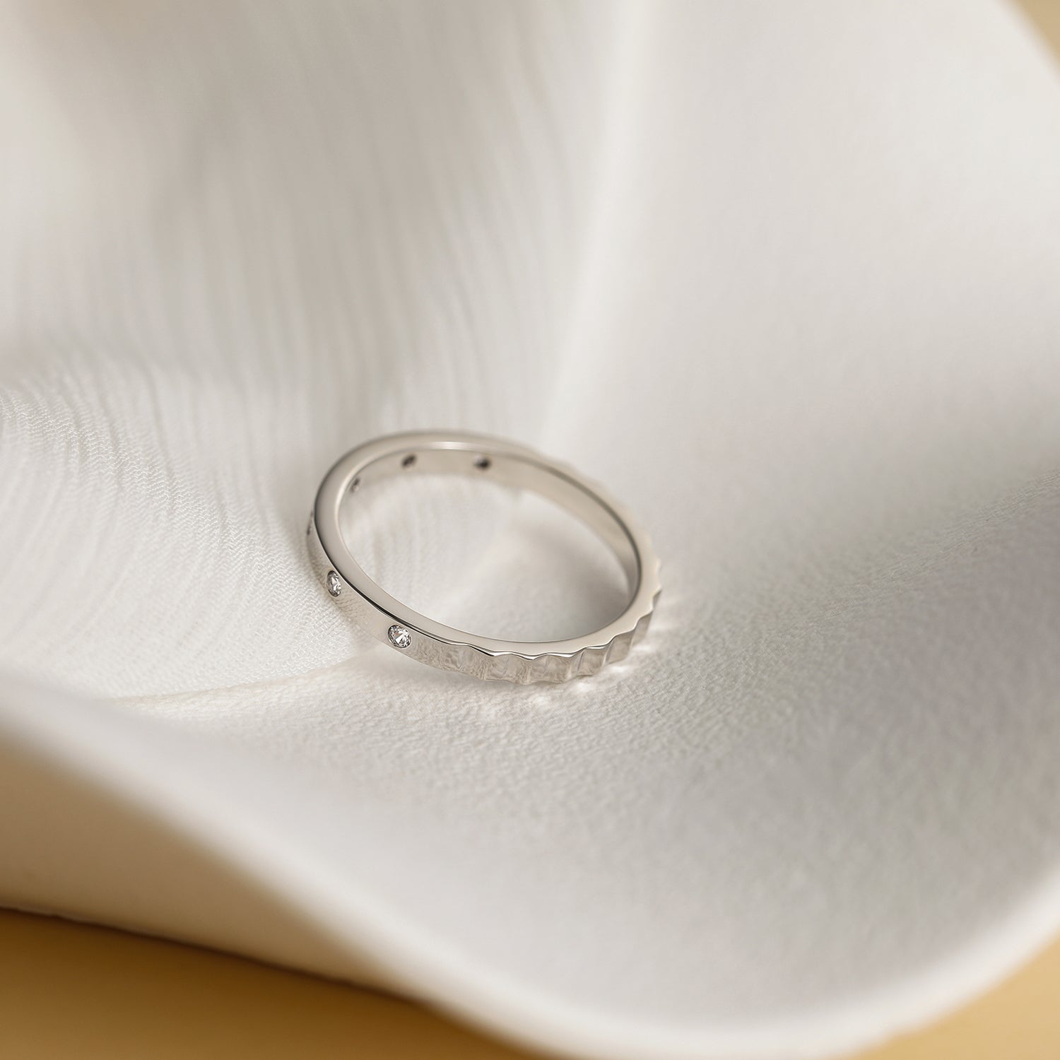 minimalist wedding band ring, 5A CZ band ring, modern promise ring, cubic zirconia Rings, cz ring, wedding rings cz, eamti rings, cheap wedding rings under $50, copper ring,stackable ring. Silver ring with small diamonds on a white ceramic dish